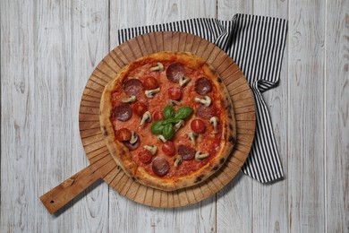 Photo of Delicious pizza with salami, tomatoes, mushrooms and basil on wooden table, top view