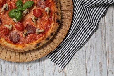 Photo of Delicious pizza with salami, tomatoes, mushrooms and basil on wooden table, top view