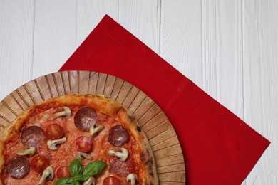 Delicious pizza with salami, tomatoes, mushrooms and basil on white wooden table, top view. Space for text