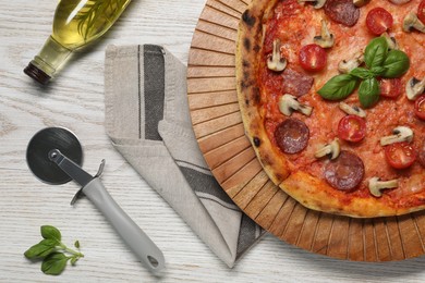 Photo of Delicious pizza with salami, tomatoes, mushrooms and basil on wooden table, flat lay