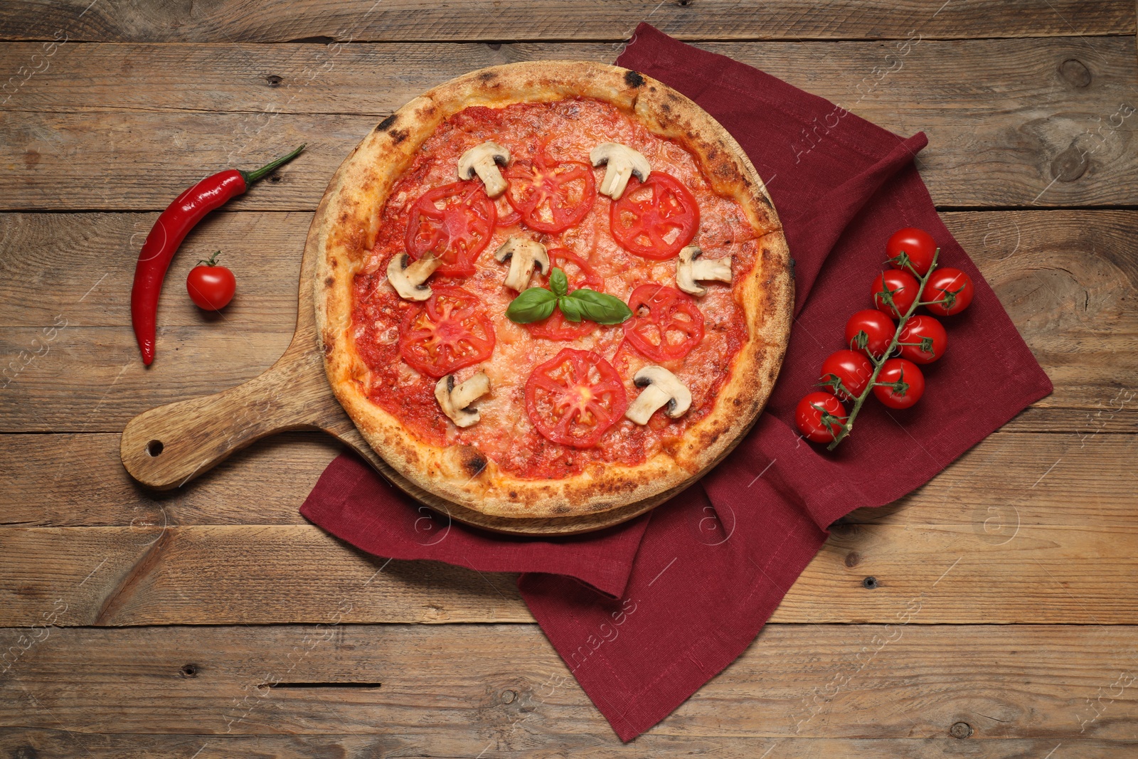 Photo of Delicious pizza with tomatoes, mushrooms, basil and chili pepper on wooden table, flat lay