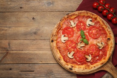 Delicious pizza with tomatoes, mushrooms and basil on wooden table, flat lay. Space for text