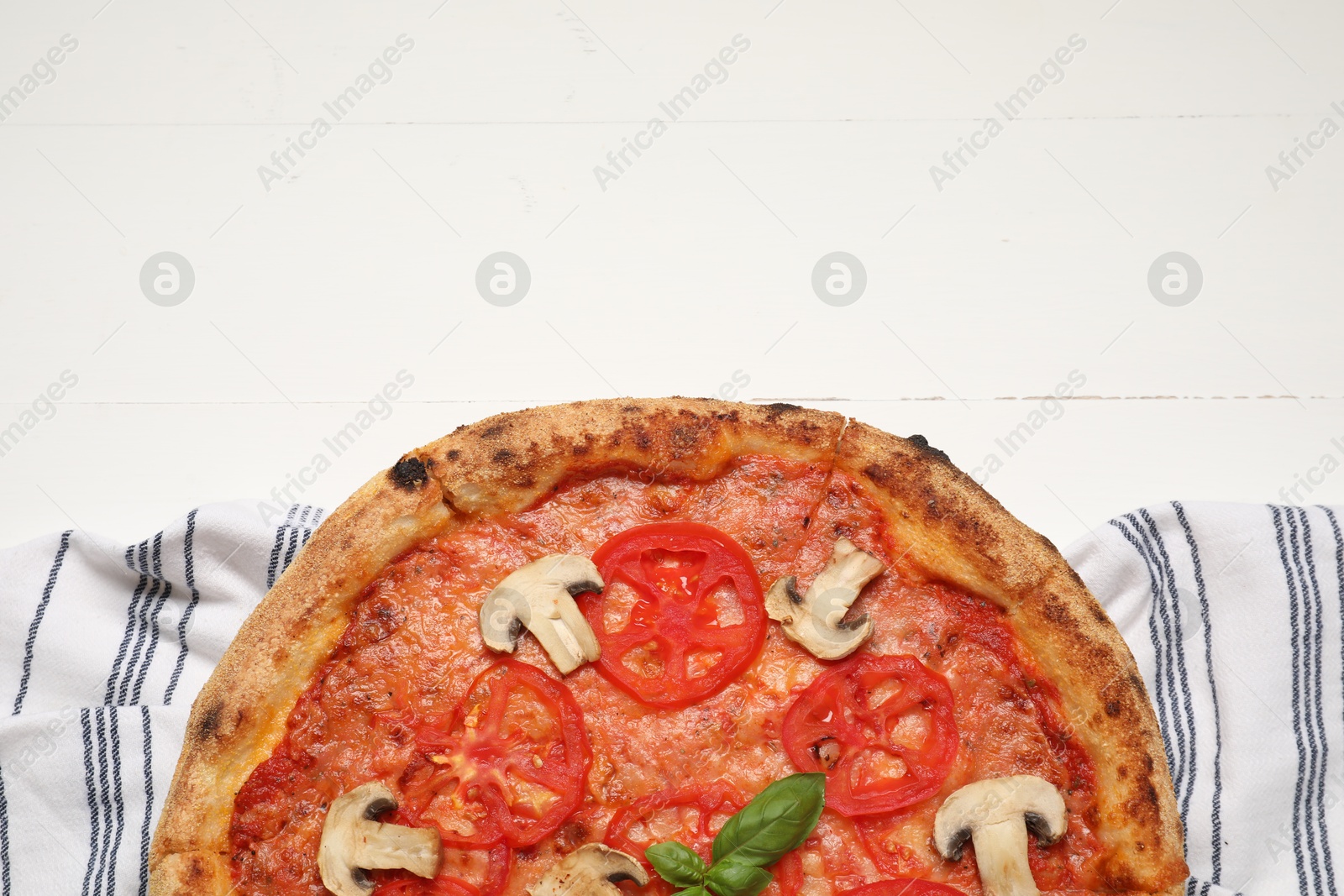 Photo of Delicious pizza with tomatoes, mushrooms and basil on white wooden table, top view. Space for text