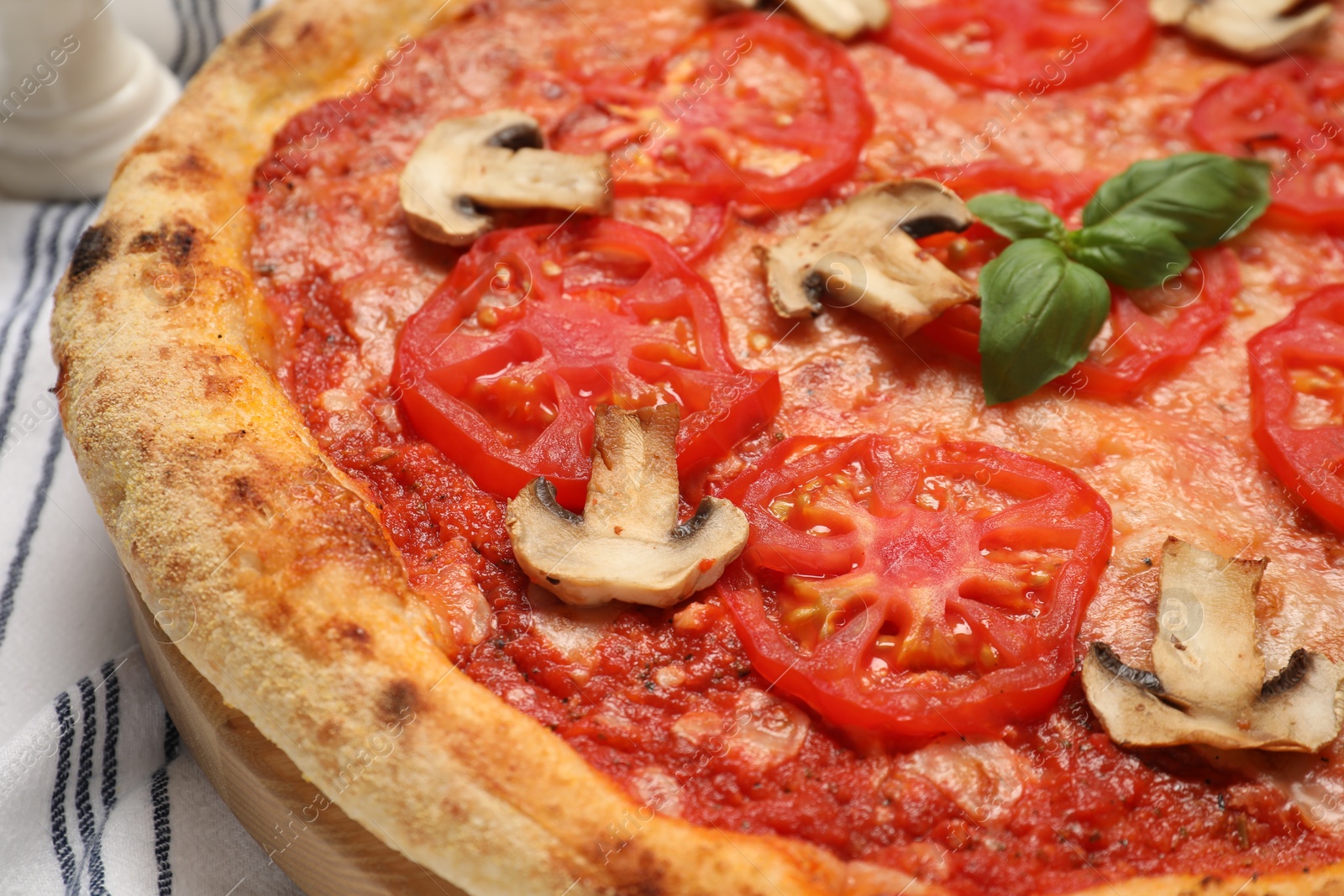 Photo of Delicious pizza with tomatoes, mushrooms and basil on table, closeup