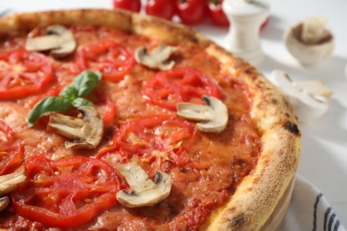 Photo of Delicious pizza with tomatoes, mushrooms and basil on table, closeup