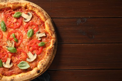 Photo of Delicious pizza with tomatoes, mushrooms and basil on wooden table, top view. Space for text