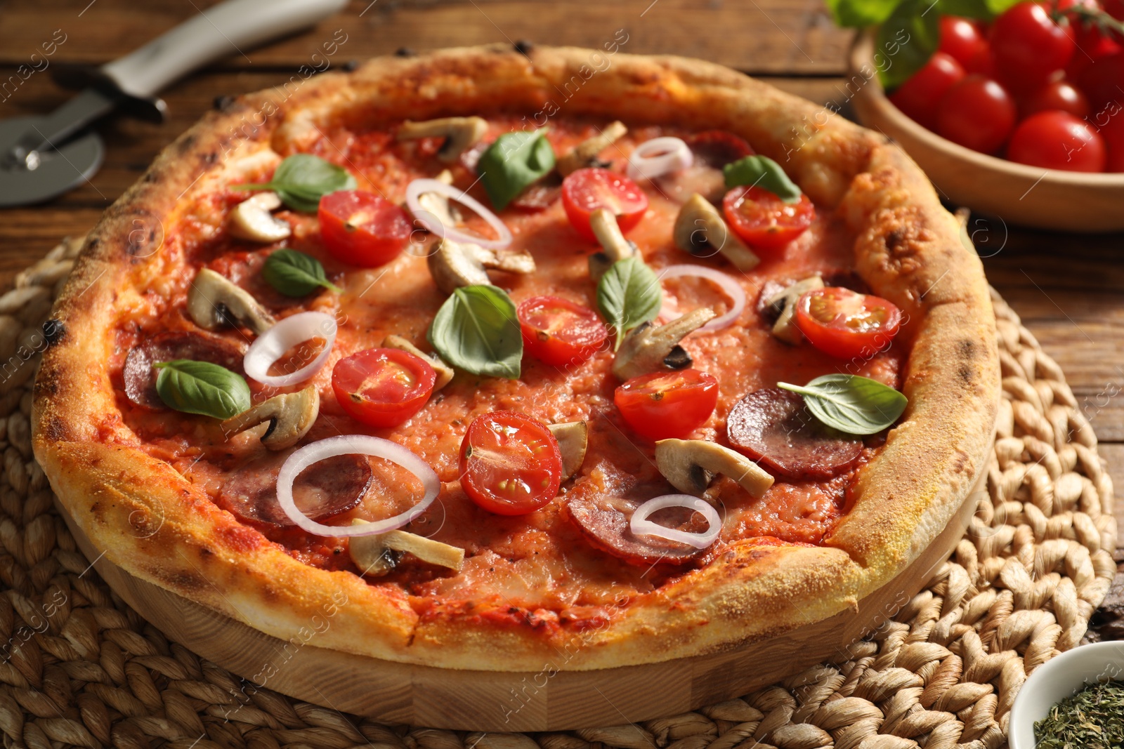 Photo of Delicious pizza with salami, vegetables, mushrooms and basil on table, closeup