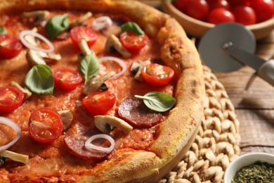 Delicious pizza with salami, vegetables, mushrooms and basil on table, closeup