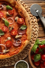 Photo of Delicious pizza with salami, vegetables, mushrooms and basil on wooden table, flat lay