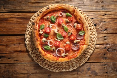 Delicious pizza with salami, tomatoes, mushrooms and basil on wooden table, top view