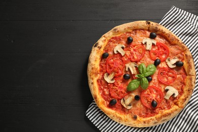 Photo of Delicious pizza with tomatoes, mushrooms, olives and basil on black wooden table, top view. Space for text