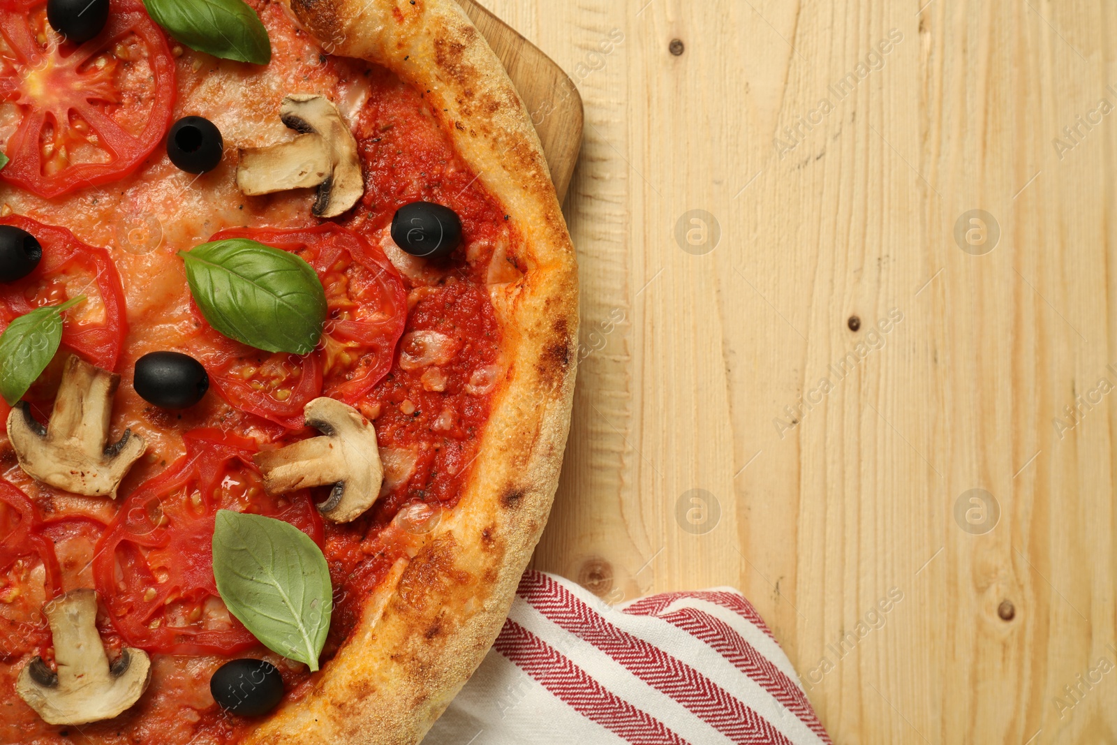 Photo of Delicious pizza with tomatoes, mushrooms, black olives and basil on wooden table, top view. Space for text