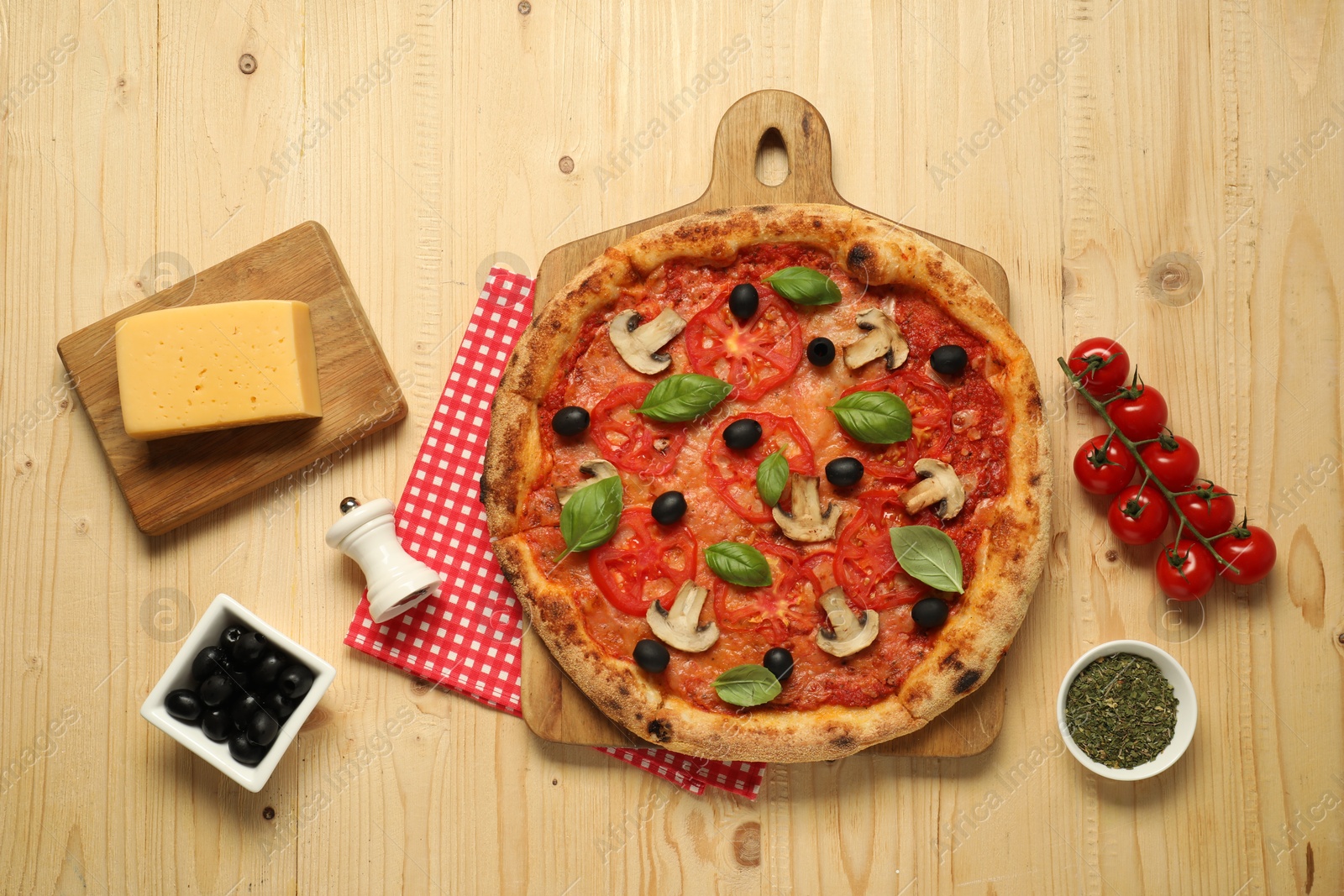 Photo of Delicious pizza with tomatoes, mushrooms, black olives and basil on wooden table, flat lay