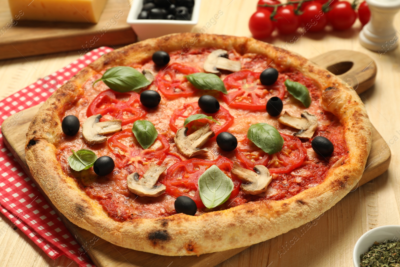 Photo of Delicious pizza with tomatoes, mushrooms, black olives and basil on wooden table, closeup