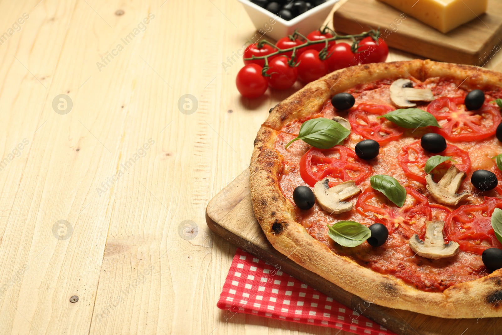 Photo of Delicious pizza with tomatoes, mushrooms, black olives and basil on wooden table, closeup. Space for text