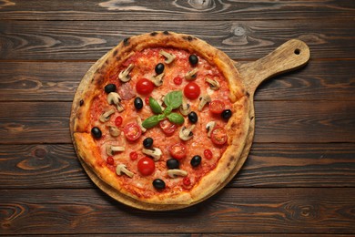 Delicious pizza with tomatoes, mushrooms, black olives and basil on wooden table, top view