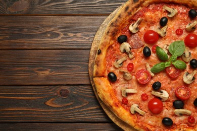 Photo of Delicious pizza with tomatoes, mushrooms, black olives and basil on wooden table, top view. Space for text