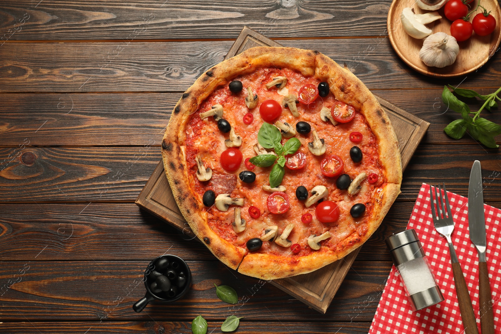 Photo of Delicious pizza with tomatoes, mushrooms, black olives and basil served on wooden table, flat lay. Space for text