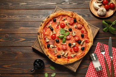 Delicious pizza with tomatoes, mushrooms, black olives and basil served on wooden table, flat lay. Space for text