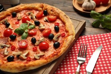 Photo of Delicious pizza with tomatoes, mushrooms, black olives and basil served on wooden table, closeup