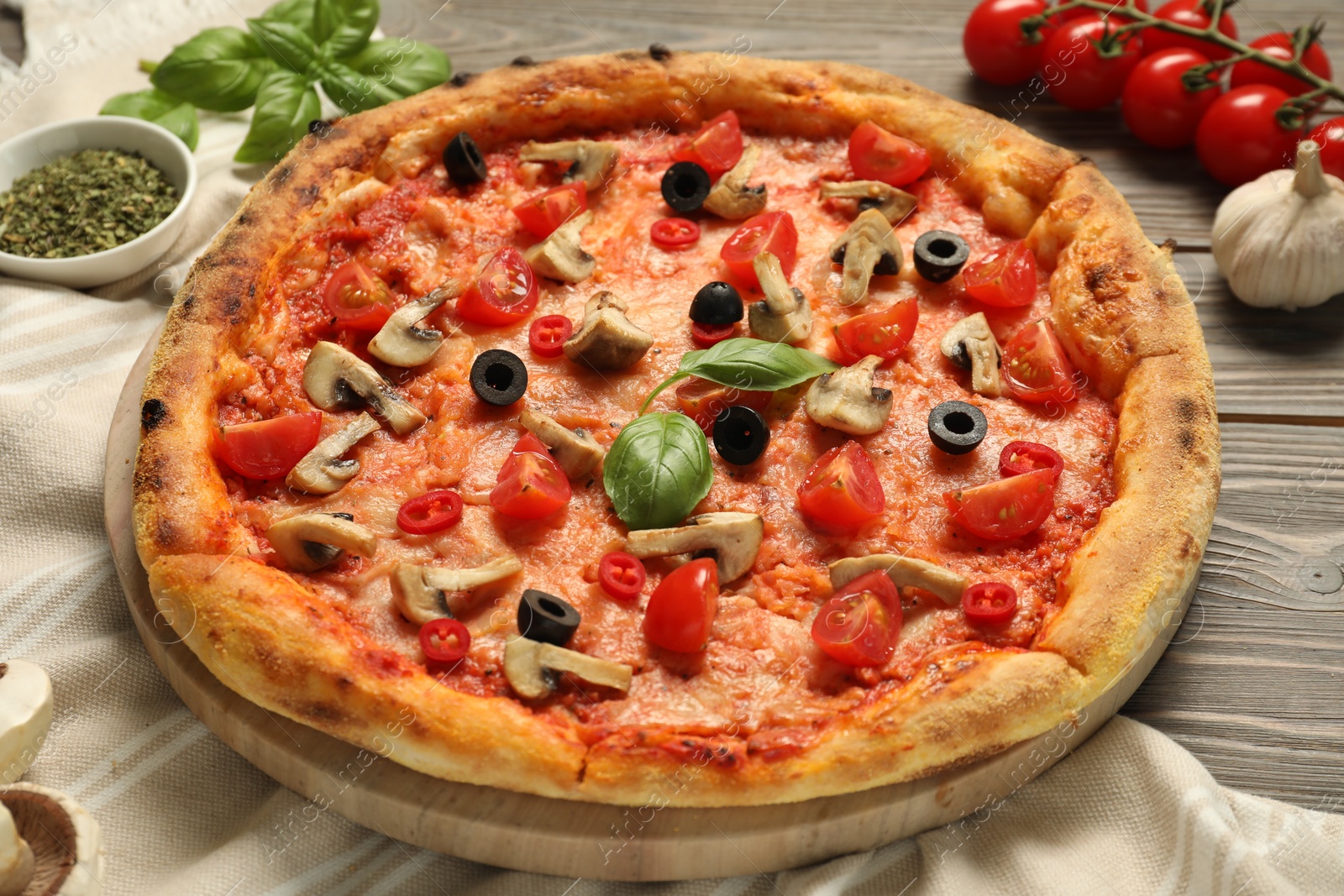 Photo of Delicious pizza with tomatoes, mushrooms, black olives and basil on wooden table, closeup