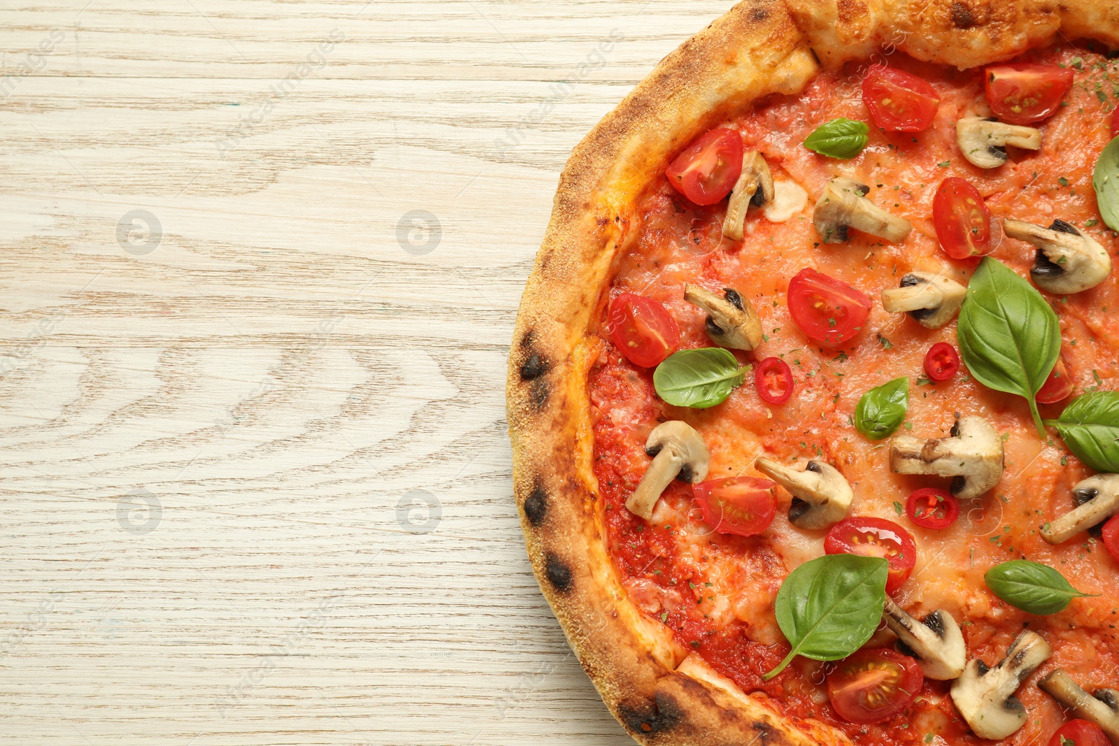 Photo of Delicious pizza with tomatoes, mushrooms and basil on wooden table, top view. Space for text