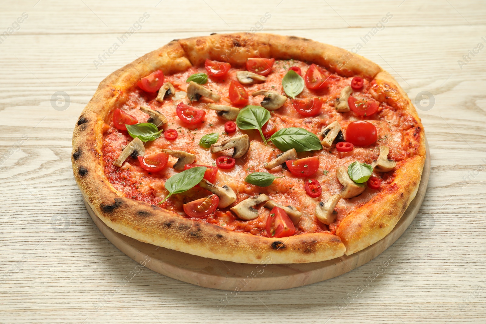 Photo of Delicious pizza with tomatoes, mushrooms and basil on wooden table, closeup