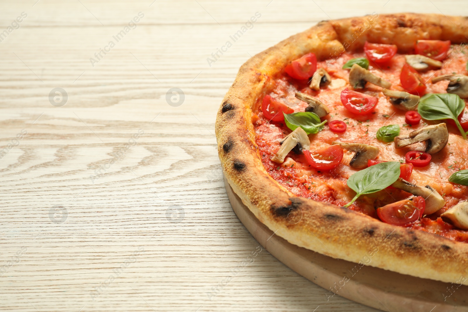 Photo of Delicious pizza with tomatoes, mushrooms and basil on wooden table, closeup. Space for text