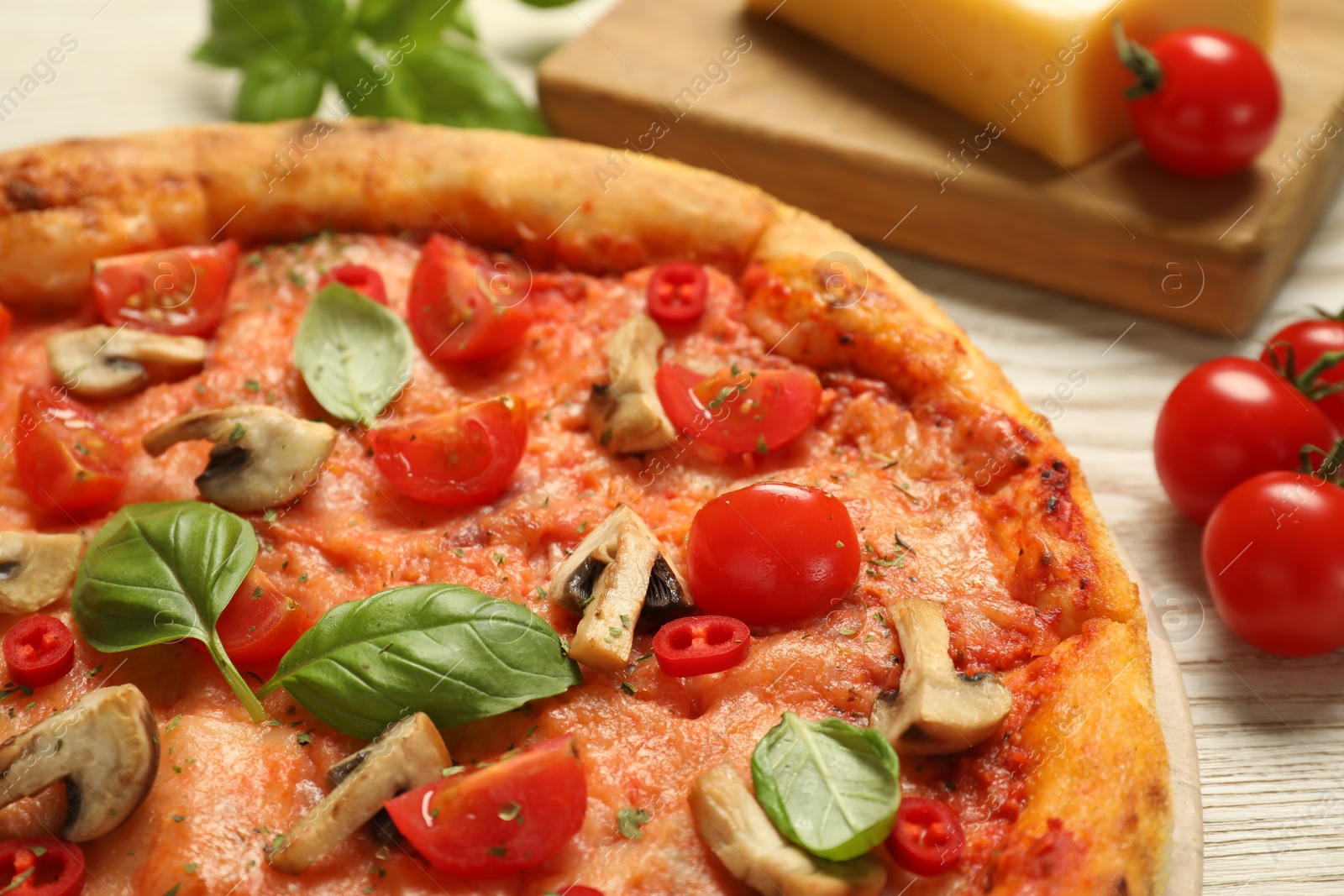 Photo of Delicious pizza with tomatoes, mushrooms and basil on wooden table, closeup