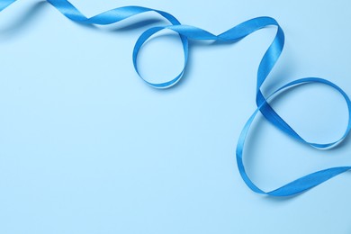 Beautiful bright ribbon on light blue background, top view. Space for text