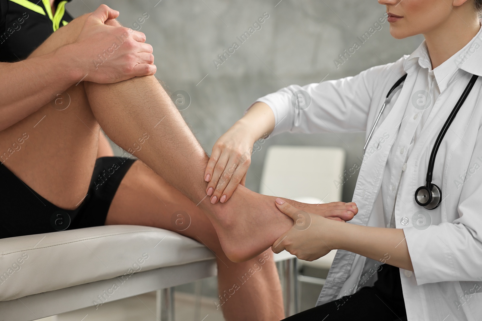 Photo of Sports injury. Doctor examining patient's foot in hospital, closeup