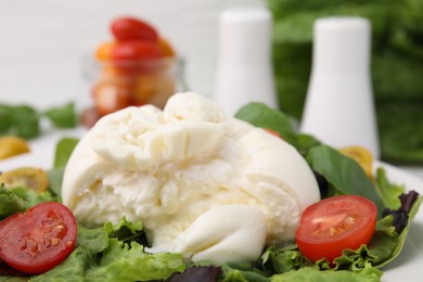 Photo of Delicious fresh burrata salad on table, closeup