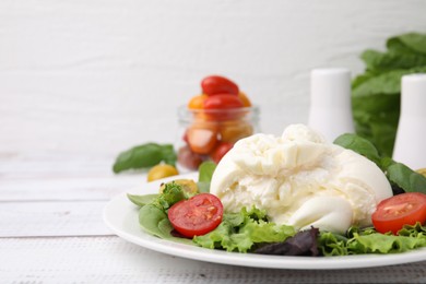 Photo of Delicious fresh burrata salad on white wooden table, closeup. Space for text