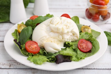 Photo of Delicious fresh burrata salad on white wooden table