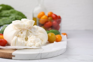 Photo of Delicious fresh burrata cheese with tomatoes on white textured table, closeup. Space for text