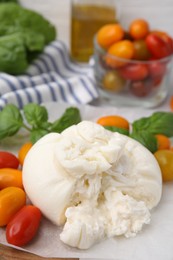 Photo of Delicious fresh burrata cheese with tomatoes on table, closeup