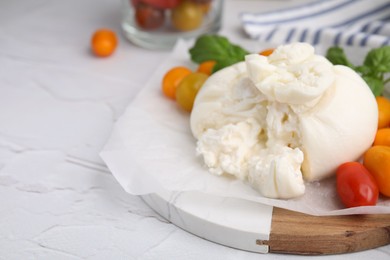 Photo of Delicious fresh burrata cheese with tomatoes on white textured table, closeup. Space for text