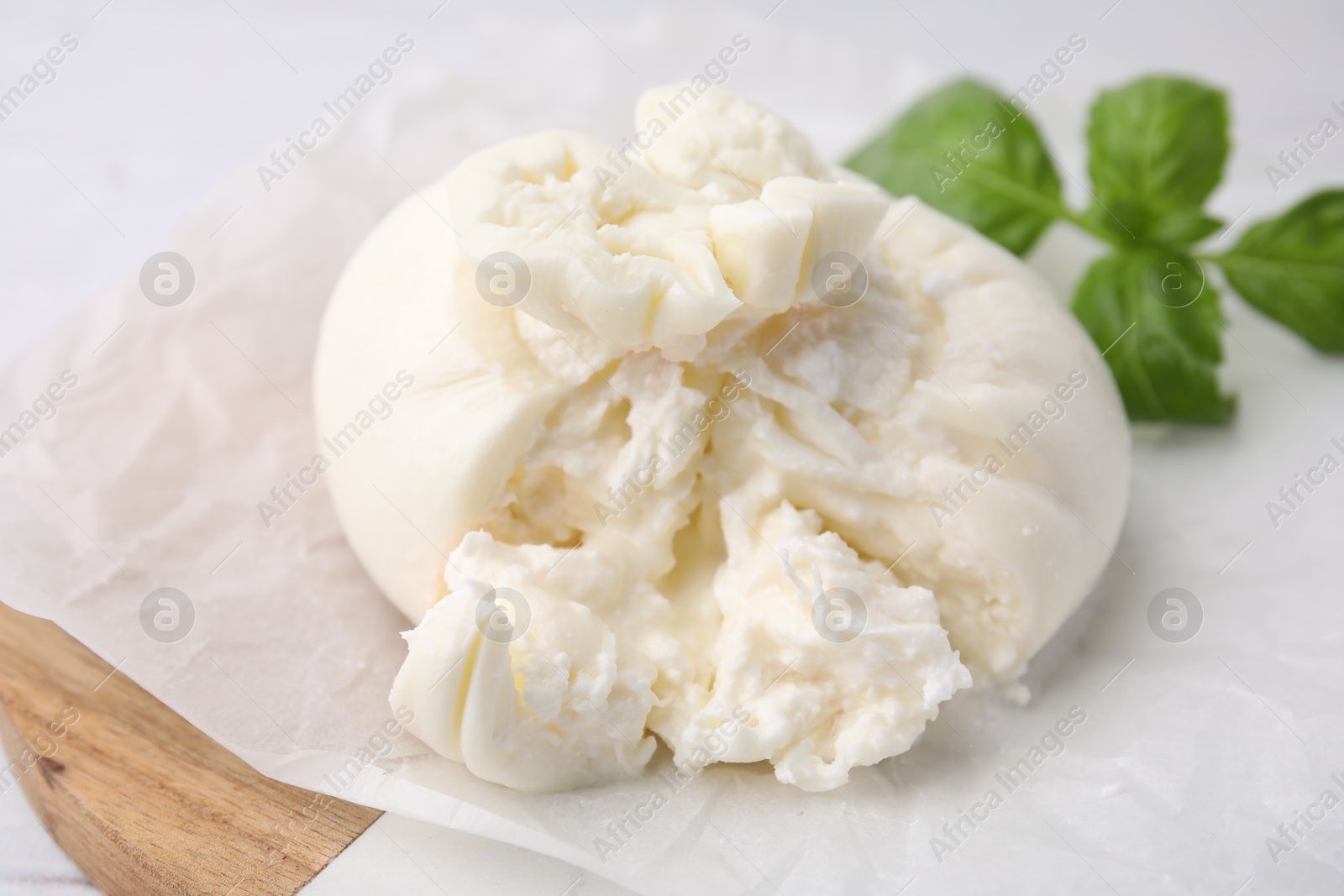 Photo of Delicious fresh burrata cheese on white table, closeup