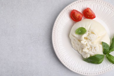 Photo of Delicious burrata cheese, tomatoes and basil on light table, top view. Space for text