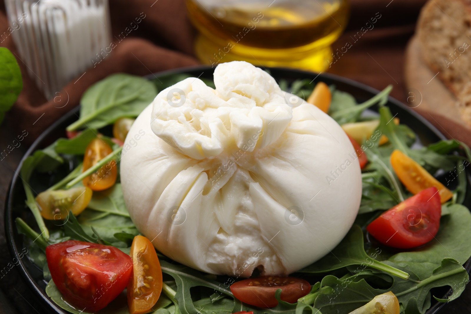 Photo of Fresh delicious burrata salad on table, closeup