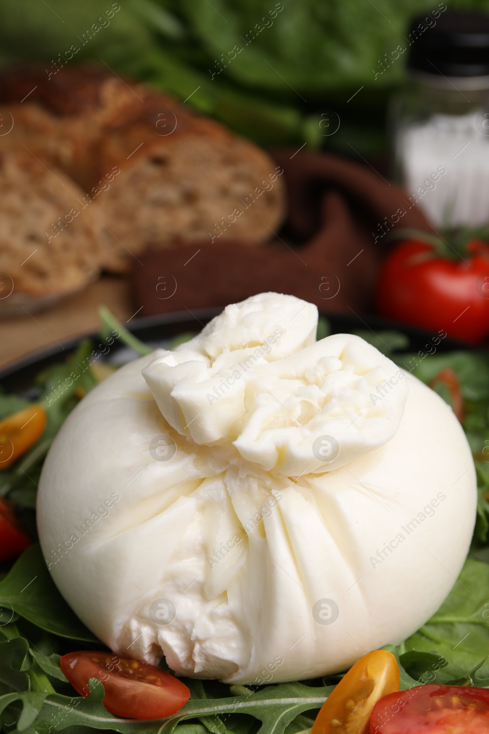 Photo of Fresh delicious burrata salad on table, closeup