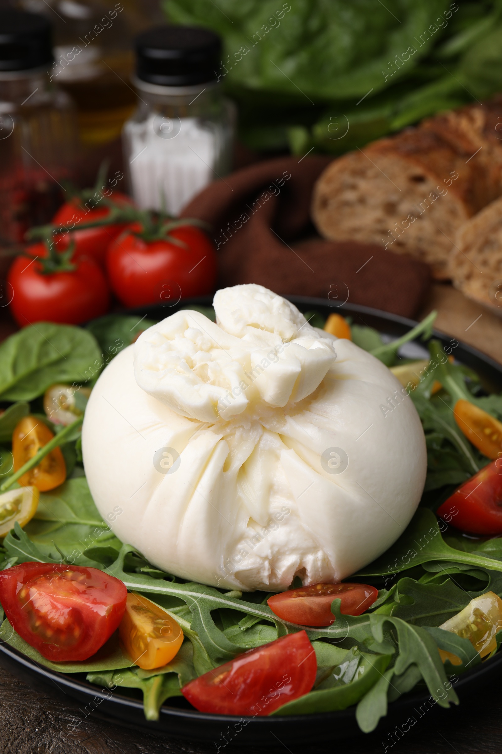 Photo of Fresh delicious burrata salad on table, closeup