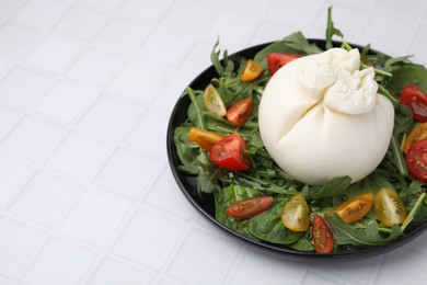 Delicious burrata salad on white tiled table, closeup. Space for text