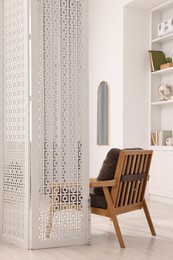 White folding screen and armchair in living room