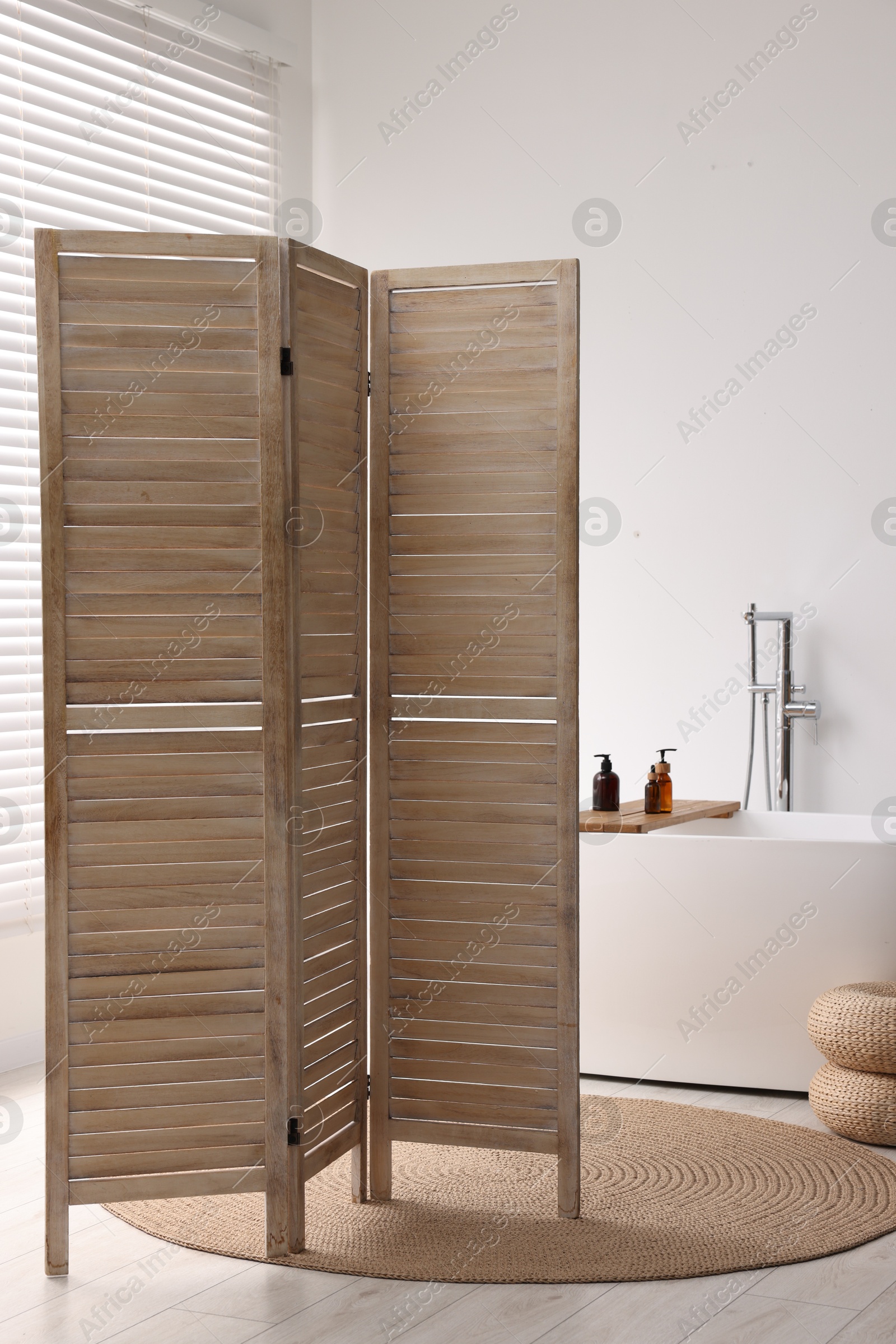 Photo of Wooden folding screen and bathtub in bathroom