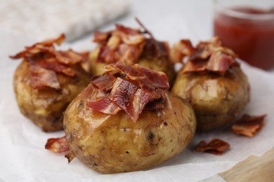 Delicious baked potatoes with bacon on table, closeup