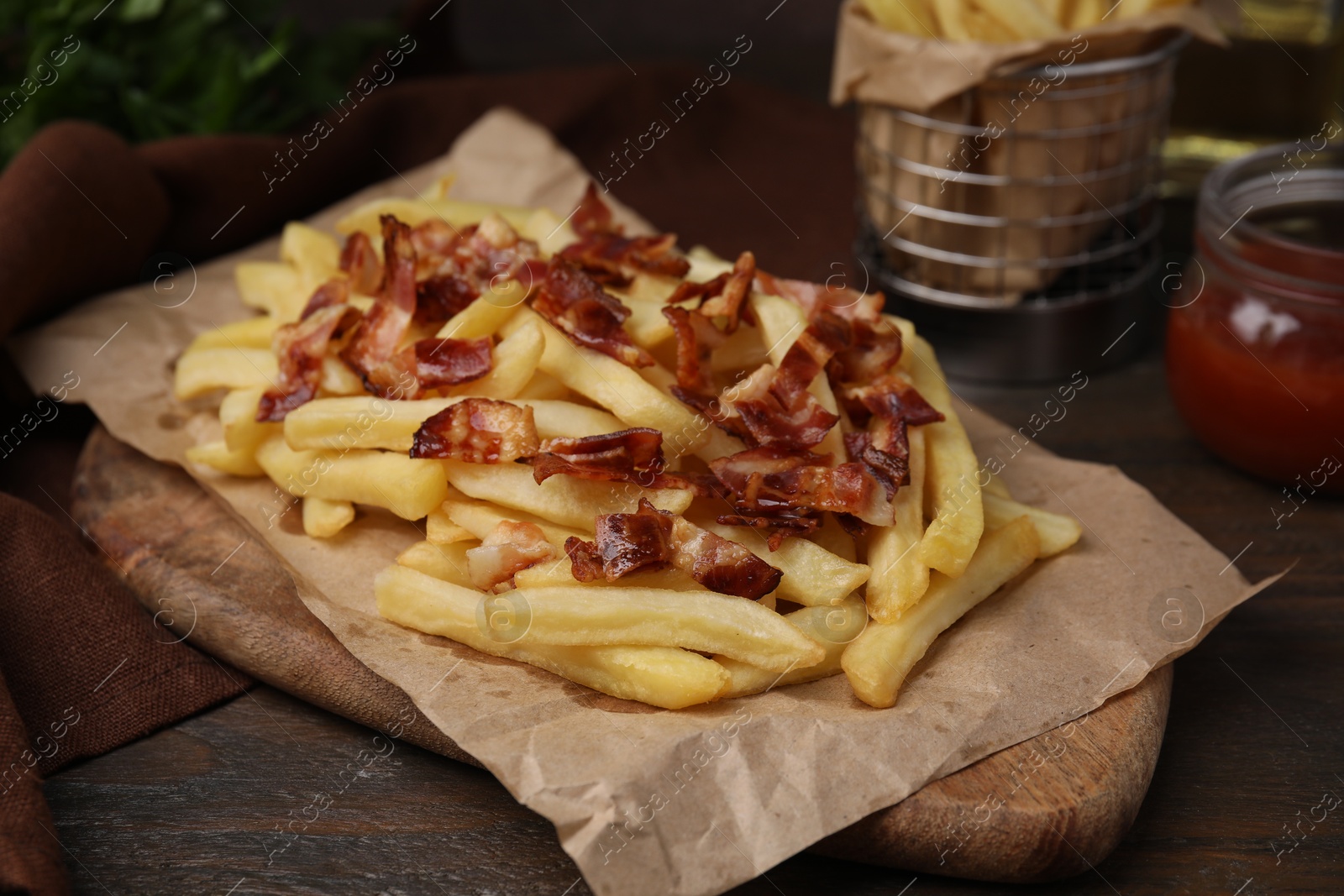 Photo of Delicious French fries with slices of bacon on wooden table, closeup