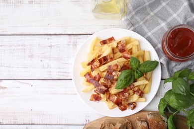 Photo of Delicious French fries with bacon, basil and ketchup on wooden rustic table, flat lay. Space for text