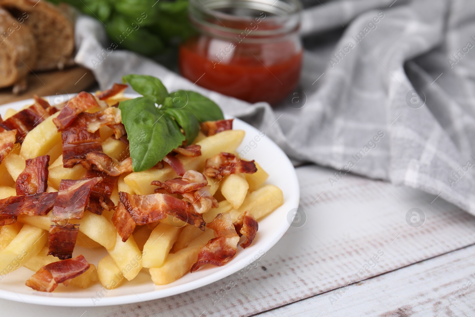 Photo of Delicious French fries with bacon and basil on wooden rustic table, closeup. Space for text