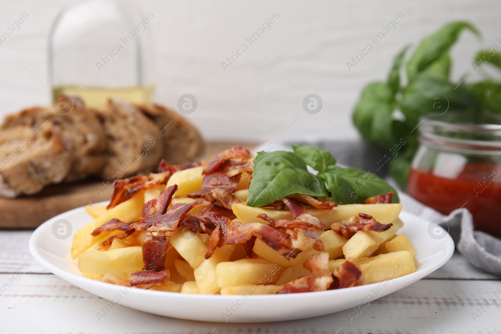 Photo of Delicious French fries with slices of bacon and basil on wooden rustic table, closeup